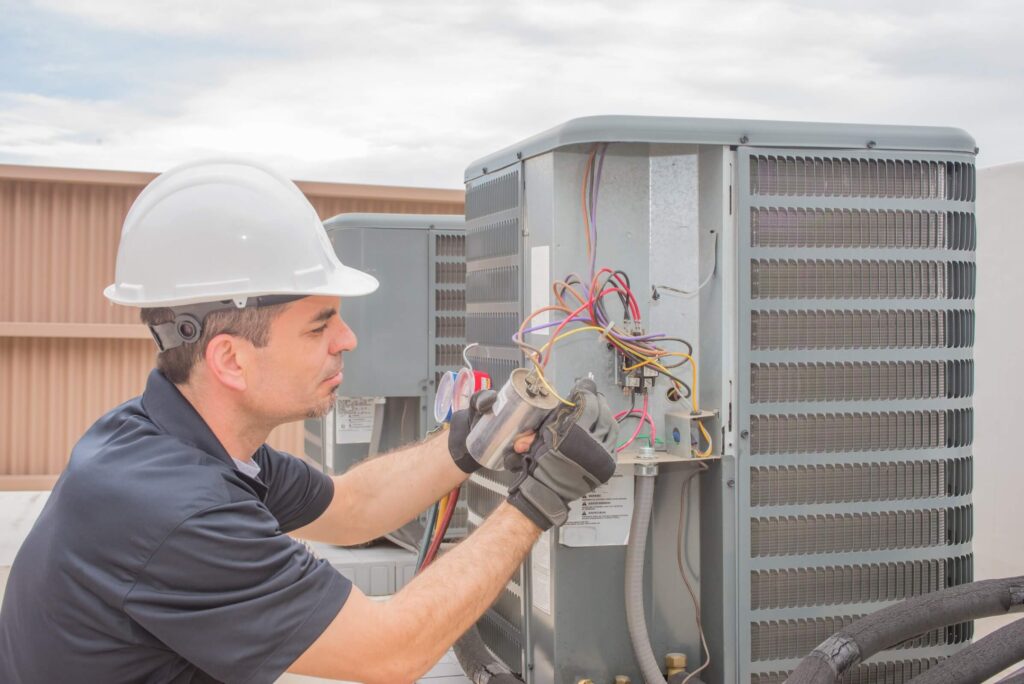 man looking at AC unit gauges